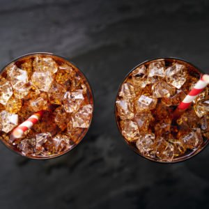 iced cola soda pop with straw in flay lay composition