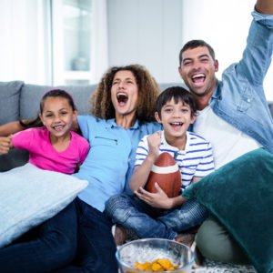 Family watching american football match on television