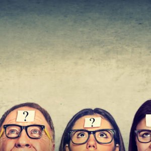 Multiethnic group of thinking people in glasses with question mark looking up