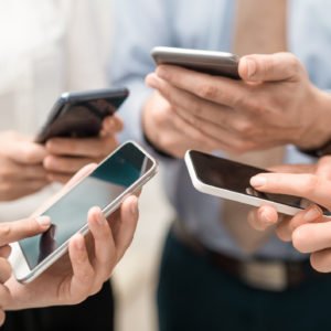 Friends having fun together with smartphones.