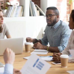 Diverse colleagues negotiate at business meeting expressing thoughts