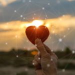 Hand holding red knit heart .